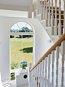 Blick durch ein Bogenfenster auf die Felder vom Treppenhaus eines Hauses in York, UK