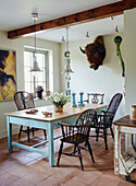 Wall mounted buffalo head and dining table with chairs in Devon home, UK