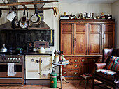 Traditionelle Bauernhausküche mit Pfannenständer und Holzkommode in einem Haus in Devon, UK