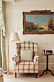 Upholstered armchair and artwork of Rialto bridge in Cotswolds home, UK