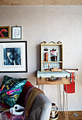 Vintage shelves and pictures with sofa in converted shipping container Bedford, UK