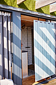 Shower cubicle with sliding door in converted shipping container Bedford, UK