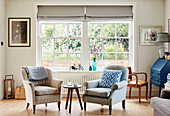 Zwei Sessel und Beistelltisch am Fenster eines Hauses in Oxfordshire, UK