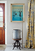Old metal bucket on antique stool with yellow curtains at entrance to North Yorkshire farmhouse, UK
