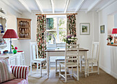 Geblümte Vorhänge und Eckschrank mit Esstisch und Stühlen in einem britischen Landhaus