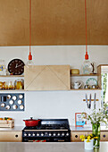 Filament bulbs with pan on hob cut flowers and kitchen shelving in Sligo newbuild, Ireland