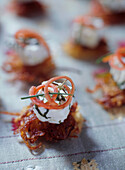 Potato and onion rosti canapes with cream cheese and tomato