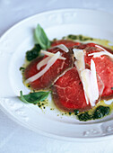 Fein geschnittenes Chateaubriand-Rindfleisch mit geriebenem Parmesan und frischem Basilikum