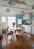 Wooden table and chairs in kitchen of Colchester family home, Essex, England, UK