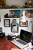 Kunstwerk und Ornamente mit Schreibtischlampe und Laptop auf Schreibtisch in einem Atelier in Colchester, Essex, England, UK