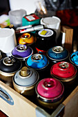 Dosen mit Sprühfarbe in Holzkiste in einem Atelier in Colchester, Essex, England, UK