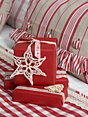 Handgemachte Schneeflocken auf rot verpackten Weihnachtsgeschenken in einem polnischen Haus