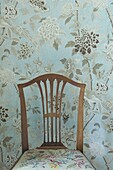 Chair, wallpaper with floral pattern behind