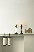 Shelf with burning candles and lanterns