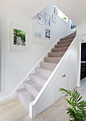 Kunstwerk in einem offenen Treppenhaus mit Teppichboden in einem Haus in Reigate, Surrey, UK
