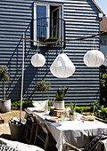 Solar lanterns above table on terrace with wood clad balcony Colchester Essex UK
