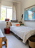 Weltkarte und Stauraum unter dem Bett mit alter Metall-Hutschachtel und Blitz-Motiv im Jungenzimmer in Colchester, Essex, UK