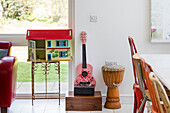 Dolls house and guitar with drum in window of Guildford home, Surrey, UK