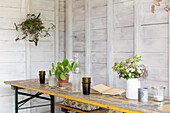 Cut flowers and houseplants on tabletop in studio shed Guildford Surrey