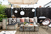 Wood decking with bench seating made of reclaimed scaffold boards in outdoor room, Cardiff, Wales, UK