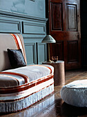 Gepolstertes kleines Sofa mit Garnituren in einem großen georgianischen Raum mit bemalter Holzvertäfelung und Holzdielenboden