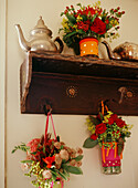 Colourful hanging flower arrangements on antique rustic coat hooks 