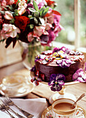 Decorated chocolate cake on cake stand at a tea party