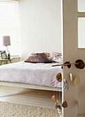 Neutral dekoriertes Schlafzimmer mit Paisley-Überwurf