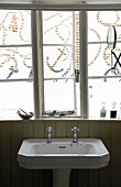 Nautische Fenster über dem Sockelwaschbecken im Badezimmer mit Nut- und Federverkleidung