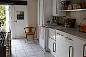Weiße Küche mit gefliestem Boden und offener Hintertür in Hastings