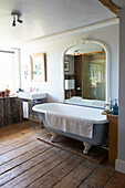Großer gewölbter Spiegel über freistehender Badewanne Iden Farmhouse, Rye, East Sussex, UK