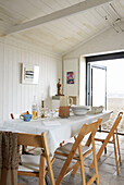 Dining table with folding chairs in Aldeburgh beach house Suffolk England UK