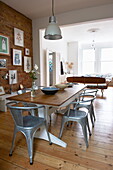 Open plan dining room with exposed brick wall in Broadstairs home, Kent, England, UK