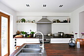Edelstahlspüle und Dunstabzug in einer modernen Küche in einem Haus in Broadstairs, Kent, England, UK