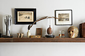 Vintage ornaments and artwork on wooden shelf in Hastings cottage, East Sussex, England, UK