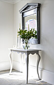 Vase with flowers on side table in modern interior