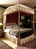 Four poster bed with floral pelmet and valance in Georgian townhouse, Laughame, Wales, UK