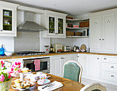 Range oven and table with cake stand in kitchen of city of Bath home Somerset, England, UK