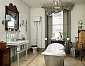 Freestanding bath and wall mounted cistern in bathroom of city of Bath home Somerset, UK