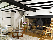 Wood burning stove in fireplace of beamed living room in Buckinghamshire cottage England UK