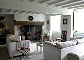 White sofas and woodburning stove in living room of Gloucestershire home, England, UK