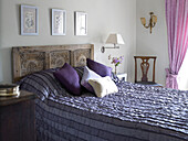 Bett in Lila-Tönen mit geschnitztem Holzkopfteil in Gloucestershire, England