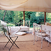 Zelt aus Segeltuch auf einer ländlichen Gartenterrasse mit Essbereich und Tagesbett