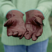 Frau mit Lederhandschuhen bei der Gartenarbeit