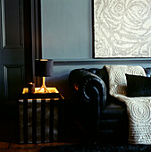 Dark living room with blue walls and black furniture