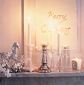Marble mantelpiece with lit candles and Christmas decorations