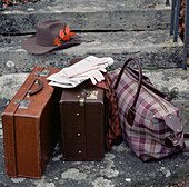Zwei braune Lederkoffer, eine Reisetasche und ein Hut auf der Eingangstreppe