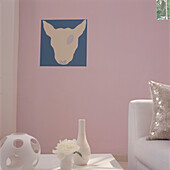 Modernes rosa gestrichenes Wohnzimmer mit weißen Möbeln und Haushaltswaren
