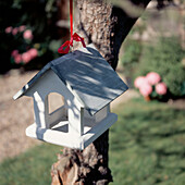 Bird house hanging in a tree in a garden