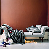 Upholstered sofa with cushions and blanket and Christmas decorations